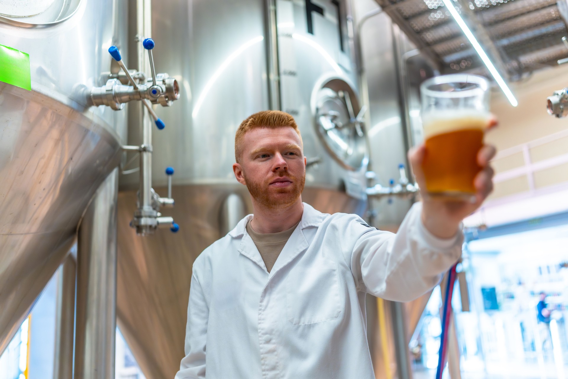 Brewmaster examining beer quality in fermentation tank area